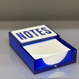 Notes desk decor note pad in translucent blue on a college students desk.