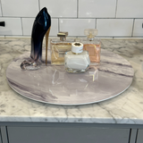 lazy susan displayed on a bathroom vanity featuring beauty products and perfumes.