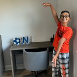 Boy sitting with custom soccer ball and initial bookends in blue and silver marble acrylic, personalized sports-themed decor for kids’ rooms