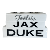 three solid white personalized pet bowls , Tootsie in grey script acrylic lettering, JAX and DUKE in black acrylic lettering