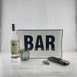 BAR tray on a bar featured with drink glass and a cocktail bottle.