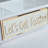 Acrylic Caddy that says Let's Get Toasted in gold mirror .