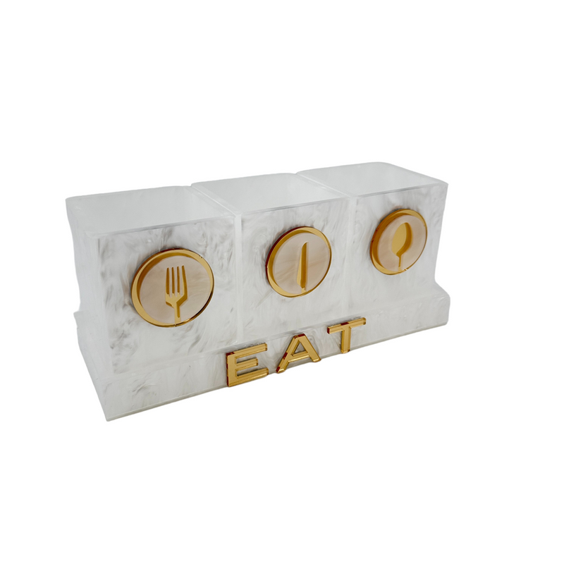 utensil caddy in white marble with 3 cups on a tray with the word EAT displayed in gold mirror acrylic acrylic.