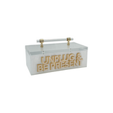 acrylic storage box that say UNPLUG & BE PRESENT in double layer letters for phones & remote control devices