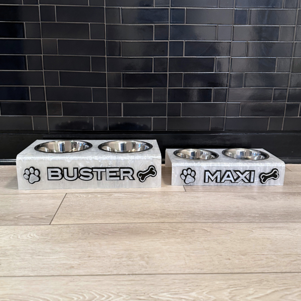 two personalized dog bowls in diifferent sizes on a kitchen floor in double layer letters and pet decals