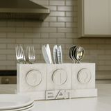 Acrylic marble cutlery holder with 'EAT' on a kitchen counter.