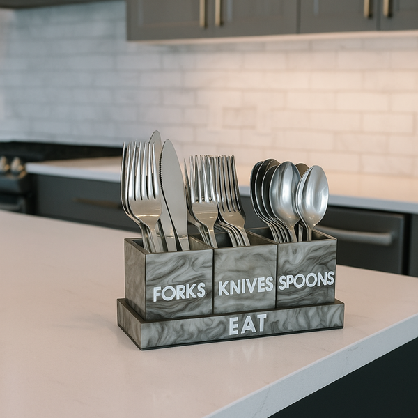 Marble-textured cutlery holder with forks, knives, and spoons on a kitchen counter.