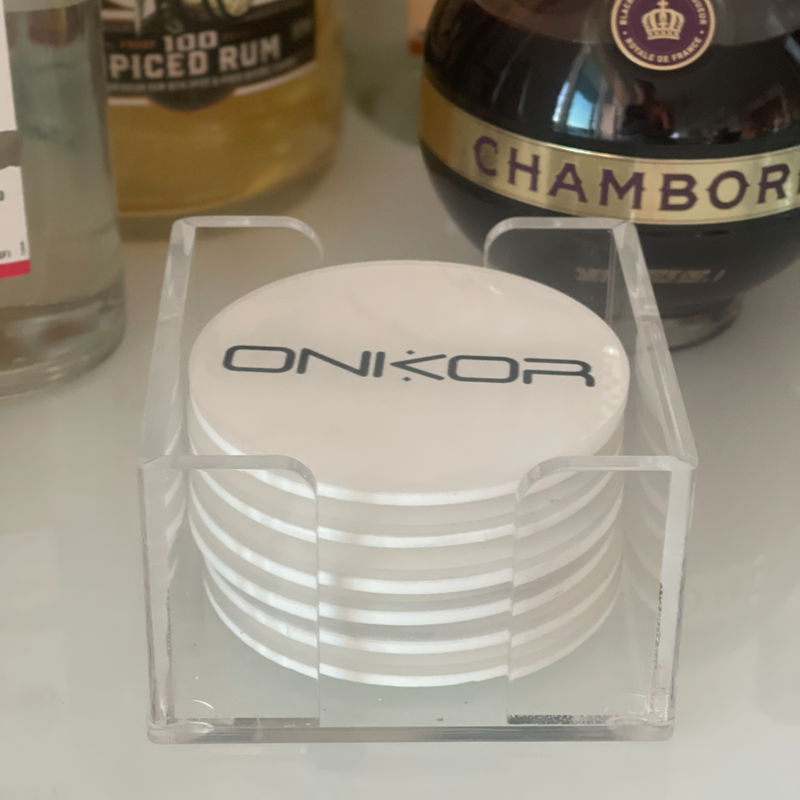 a set of 6 round acrylic white solid coasters in a clear acrylic holder with a personalized business logo 