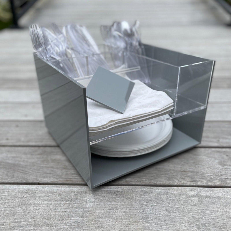 solid grey acrylic deluxe caddy on a lazy susan holds condiments, forks, soons, knives and paper plates.