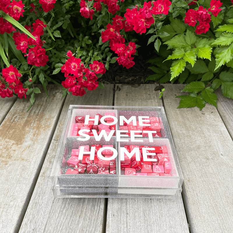 HOME SWEET HOME CANDY tray displayed on a wooden table and flowers.