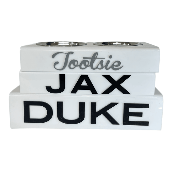three solid white personalized pet bowls , Tootsie in grey script acrylic lettering, JAX and DUKE in black acrylic lettering