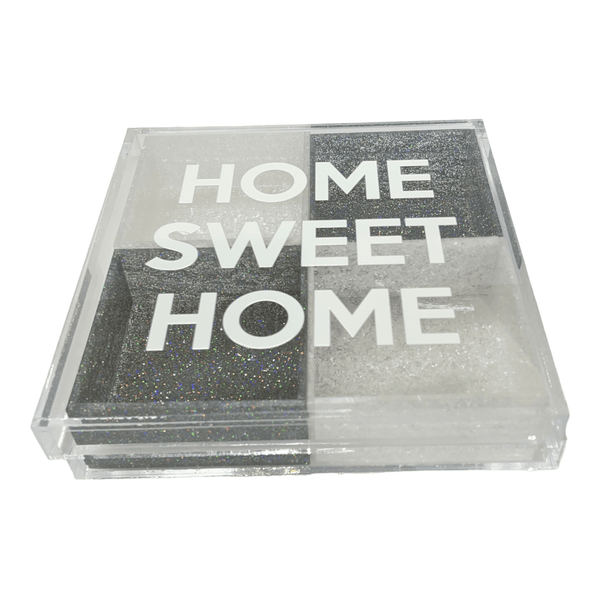 a clear acrylic tray on a rotating base with 4 colored boxes and a lid that has a sticker that says HOME SWEET HOME