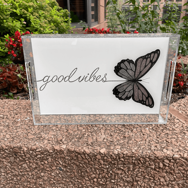 good vibes tray with butterfly print and good vibes written in script, sparkle in a garden next to flowers 