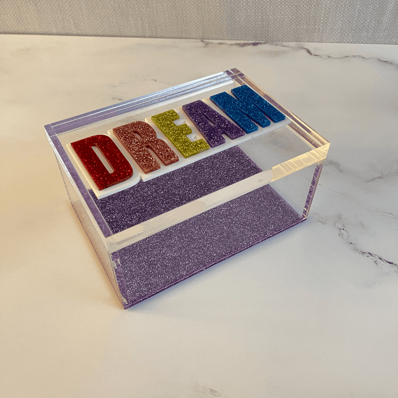 DREAM clear acrylic box with purple sparkle bottom and colorful acrylic lettering on marble dresser