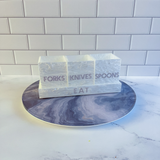 white marble utensil caddy featured on a lazy susan on a kitchen island