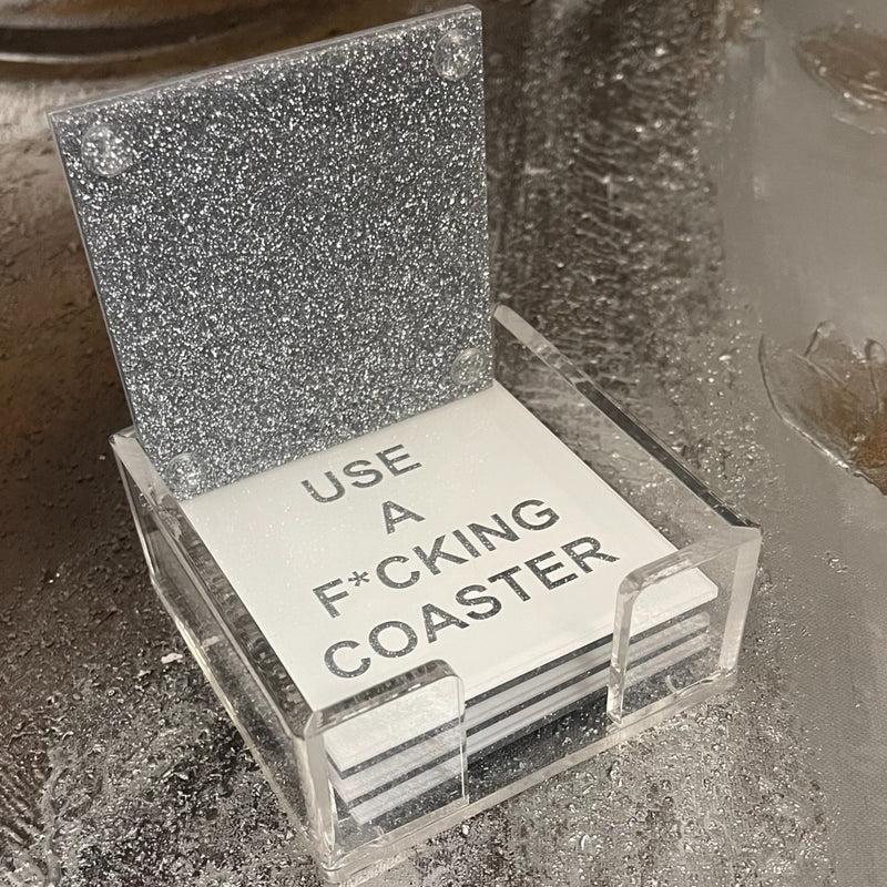 white coaster set with showing silver sparkle bottom of coaster displayed on a cocktail table